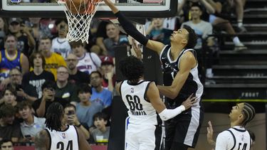 Victor Wembanyama, de los Spurs de San Antonio, retaca el balón sobre Justin Minaya, de los Trail Blazers de Portland, durante la primera mitad del juego de baloncesto de la Liga de Verano de la NBA, el domingo 9 de julio de 2023, en Las Vegas. (AP Foto/John Locher)