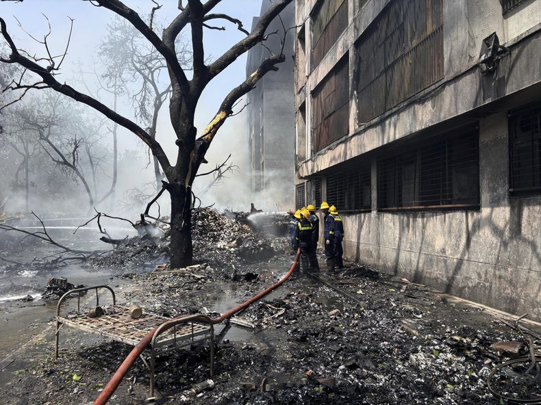 Bomberos trabajan en el lugar donde se estrelló un avión en la ciudad noroccidental de Ahmedabad, en el estado de Gujarat, India, el jueves 12 de junio de 2025. (AP Foto/Ajit Solanki)