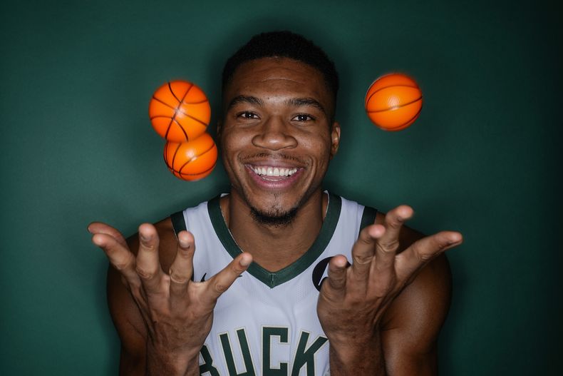 Giannis Antetokounmpo de los Bucks de Milwaukee posa para las fotos del equipo lanzando unas pelotas al aire durante el día de medios el lunes dos de octubre del 2023. (AP Foto/Morry Gash)