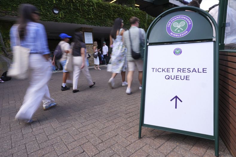 La gente recoge entradas en una oficina de reventa durante el Campeonato de Tenis de Wimbledon en Londres, el jueves 3 de julio de 2025. (AP Photo/Kirsty Wigglesworth)