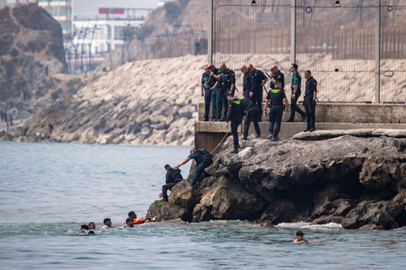 Migrantes tratan de cruzar hacia enclave español de Ceuta en Marruecos, el 30 de julio del 2026. (AP foto/Antonio Sempere)