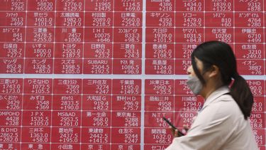 Una persona pasa por delante de una pantalla con cotizaciones en una empresa bursátil, en Tokio, el 10 de abril de 2025. (Kyodo News vía AP)