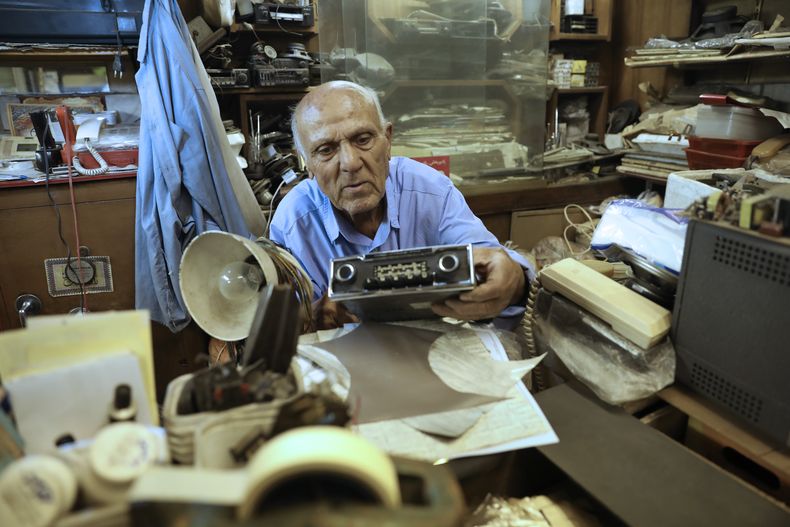 Reza Alimirzaei, de 73 años, que repara y vende radios viejas, trabaja en su tienda en el centro de Teherán, Irán, el miércoles 18 de septiembre de 2024. (Foto AP/Vahid Salemi)