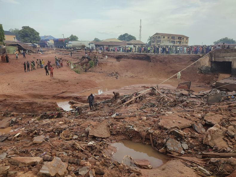 Personas revisan una zona que se inundó tras fuertes lluvias en Mokwa, Nigeria, el viernes 30 de mayo de 2025. (AP Foto/Chenemi Bamaiyi)