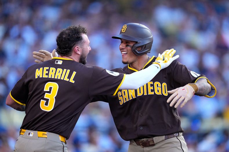Manny Machado, de los Padres de San Diego, a la derecha, es felicitado por Jackson Merrill tras conectar un jonrón de tres carreras durante la séptima entrada de un partido de béisbol contra los Dodgers de Los Ángeles, el domingo 5 de julio de 2026, en Los Ángeles. (Foto AP/Mark J. Terrill)