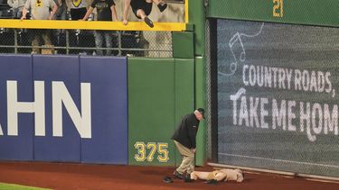 Un fanático yace en la fanja de advertencia del PNC Park, tras caer desde las gradas en el encuentro entre los Piratas de Pittsburgh y los Cachorros de Chicago, el miércoles 30 de abril de 2025 (AP Foto/Gene J. Puskar)