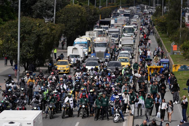 Motociclistas bloquean una calle durante una protesta contra un decreto emitido por el alcalde de Bogotá que prohíbe los pasajeros en motocicletas y restringe la circulación de motocicletas por la noche durante cinco días, en Bogotá, Colombia, el jueves 30 de octubre de 2025. (AP Foto/Fernando Vergara)