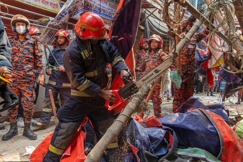 Rescatistas y bomberos cortan andamios que cayeron tras un sismo, en Daca, Bangladesh, el 21 de noviembre de 2025. (AP Foto/Abdul Goni)