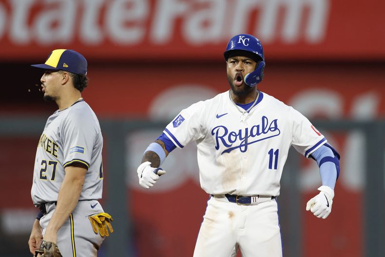 El venezolano de los Reales de Kansas City Maikel García (11) reacciona próximo al campocorto dominicano de los Cerveceros de Milwaukee Willy Adames (27) al conectar un doblete remolcador de dos carreras durante la 7ma entrada del juego de béisbol en Kansas City, Misuri, el lunes 6 de mayo de 2024. (AP Foto/Colin E. Braley)
