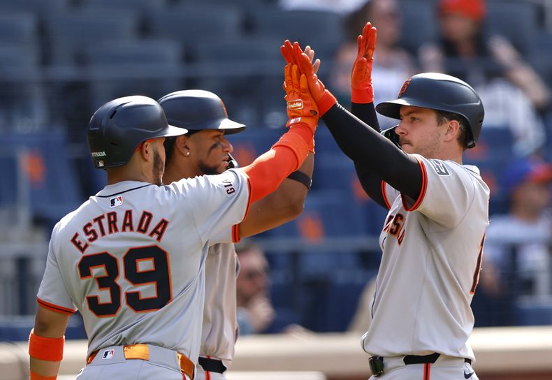 Thairo Estrada (39), Luis Matos, centro, y Patrick Bailey, derecha, de los Gigantes de San Francisco, celebran después de anotar durante la décima entrada del juego de béisbol contra los Mets de Nueva York, el sábado 25 de mayo de 2024, en Nueva York. (AP Foto/Noah K. Murray)