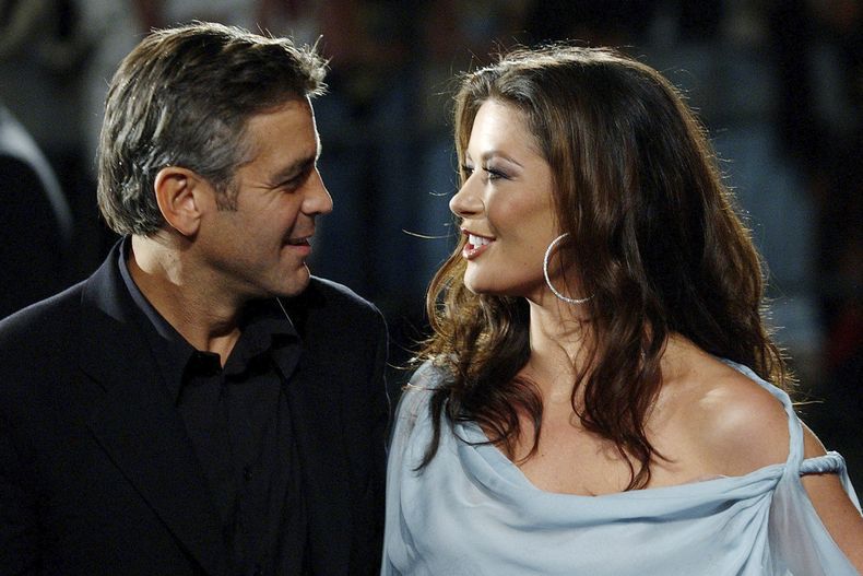 ARCHIVO - El actor estadounidense George Clooney, a la izquierda, y la actriz galesa Catherine Zeta-Jones aparecen en la proyección de su película Intolerable Cruelty fuera de competición en el 60º Festival de Cine de Venecia en Venecia, Italia, el miércoles 3 de septiembre de 2003. (Foto AP/Luca Bruno, archivo)