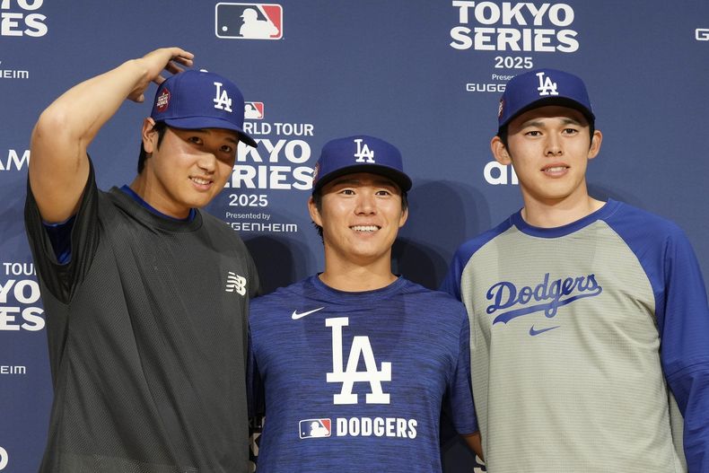 Shohei Ohtani de los Dodgers de Los Ángeles, con sus compañeros, Yoshinobu Yamamoto y Roki Sasaki posan para las fotos tras la conferencia de prensa antes de la serie ante los Cachorros de Chicago en Tokio el viernes 14 de marzo del 2025. (AP Foto/Eugene Hoshiko)
