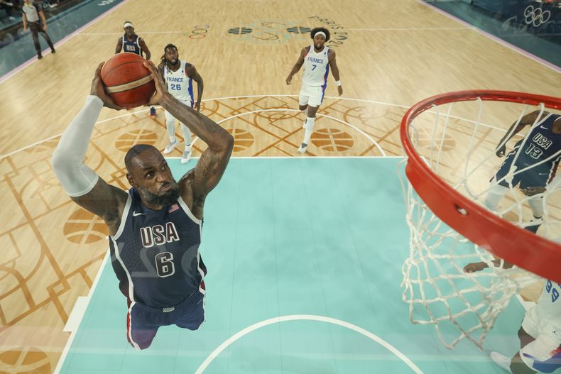 El estadounidense LeBron James (6) clava el balón durante la final contra Francia en el baloncesto masculino de los Juegos Olímpicos de París, el sábado 10 de agosto de 2024. (AP Foto/Gregory Shamus/Pool Foto vía AP)