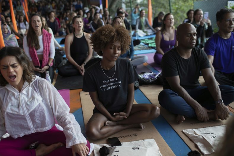 Varias personas meditan durante una clase de yoga del Proyecto Transformación en la favela Rocinha, en Río de Janeiro, el miércoles 9 de julio de 2025. (AP Foto/Bruna Prado)