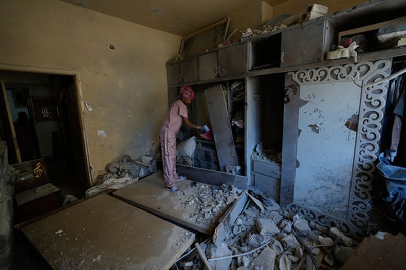 Una trabajadora doméstica limpia un dormitorio dañado en la ciudad portuaria de Tiro, en el sur de Líbano, el jueves 30 de abril de 2026 mientras el propietario vuelve a la vivienda. (AP Foto/Hussein Malla)
