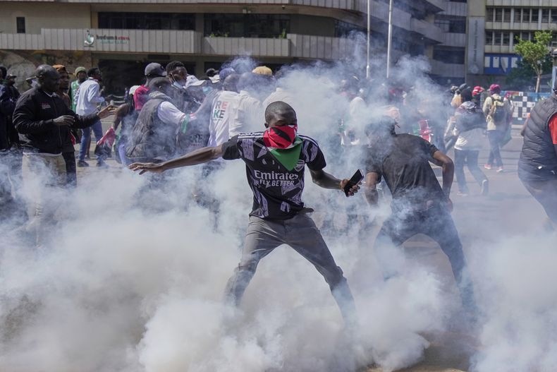 Manifestantes se dispersan mientras la policía les arroja gas lacrimógeno durante una protesta en el centro de Nairobi, Kenia, el miércoles 25 de junio de 2025. (AP Foto/Brian Inganga)