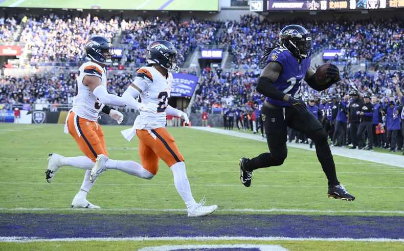 Derrick Henry, derecha, running back de los Ravens de Baltimore, se enfila rumbo a un touchdown mientras el safety Devon Key, centro, y el linebacker Cody Barton, de los Broncos de Denver, lo persiguen en la segunda mitad del juego de la NFL, el domingo 3 de noviembre de 2024, en Baltimore. (AP Foto/Nick Wass)