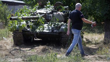 americateve | Un hombre pasa al lado de un tanque camuflado en el poblado de Novoazovsk, en el este de Ucrania, el viernes 29 de agosto de 2014. (Foto AP/Sergei Grits)