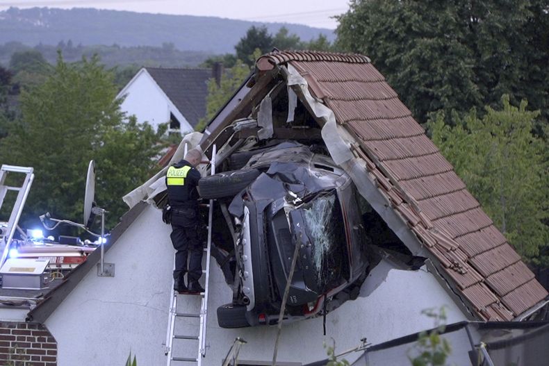 Un policía revisa un automóvil atascado en un granero después de un accidente en Bohmte, Alemania, el domingo 20 de julio de 2025. (Torben Kipp/Nordwestmedia-TV/dpa vía AP)