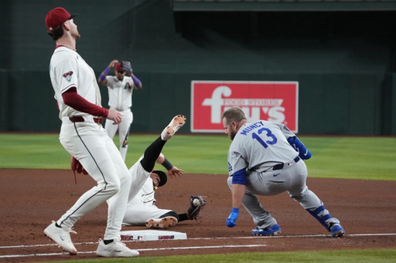 Max Muncy, de los Dodgers de Los Ángeles, y el venezolano Ildemaro Vargas, de los Diamondbacks de Arizona, chocan durante el juego del jueves 4 de junio de 2026 (AP Foto/Rick Scuteri)