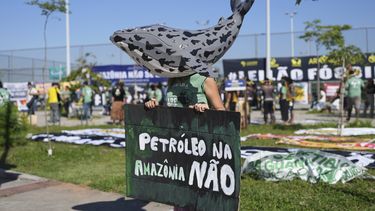 Un manifestante con una ballena hecha de papel en la cabeza sostiene un letrero con la frase No al petróleo en la Amazonía en portugués, el martes 17 de junio de 2025 en Río de Janeiro, en protesta contra la subasta de sitios petroleros. (AP Foto/Silvia Izquierdo
