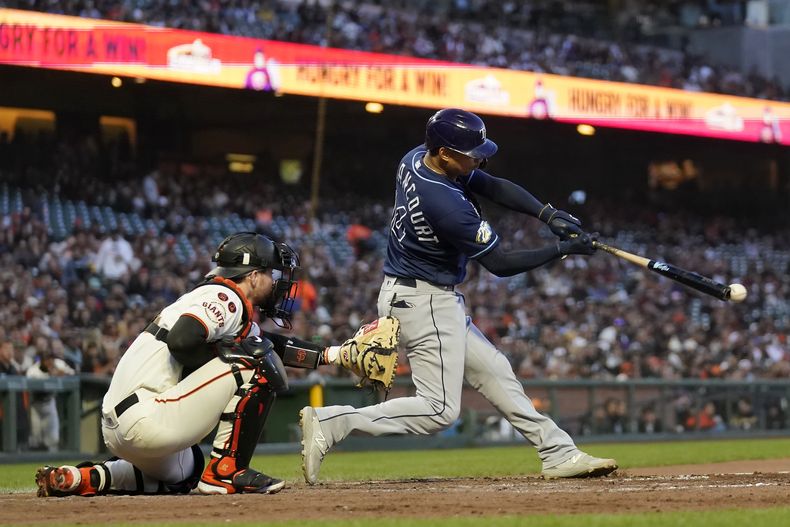 Christian Bethancourt de los Rays de Tampa Bay pega un sencillo remolcador frente al cátcher de los Gigantes de San Francisco Patrick Bailey en el quinto episodio del encuentro del lunes 14 de agosto del 2023. (AP Foto/Jeff Chiu)