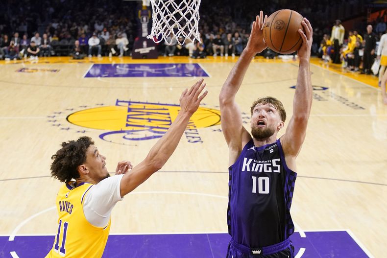 El lituano Domantas Sabonis, de los Kings de Sacramento, encesta frente a Jaxson Hayes, de los Lakers de Los Ángeles, en el duelo del miércoles 15 de noviembre de 2023 (AP Foto/Mark J. Terrill)