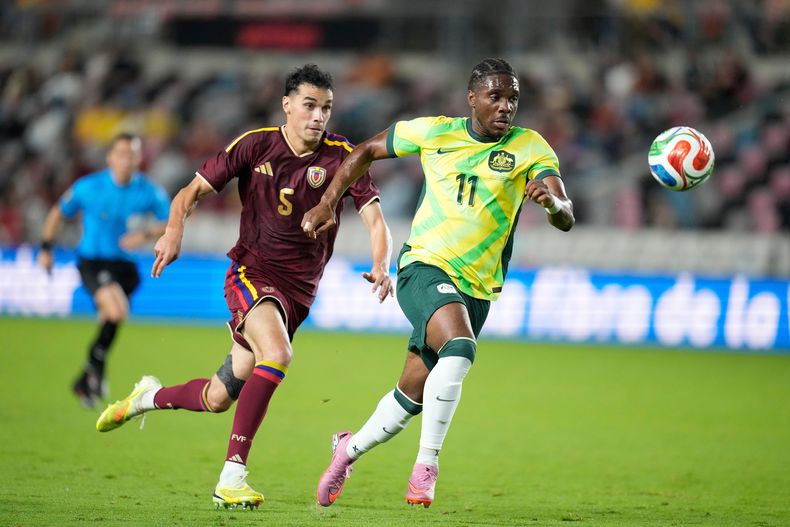 Al Hassan Toure (11), de Australia, y Teo Quintero León (5), de Venezuela, persiguen el balón durante la segunda mitad de un juego amistoso internacional de fútbol, el viernes 14 de noviembre de 2025, en Houston. (AP Photo/Karen Warren)