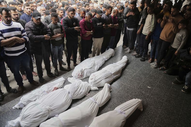 Dolientes oran junto a los cuerpos de varios palestinos muertos en un ataque aéreo israelí en el barrio de Shijaiyah, mientras son trasladados al Hospital Bautista en la Ciudad de Gaza, el miércoles 9 de abril de 2025. (AP Foto/Jehad Alshrafi)