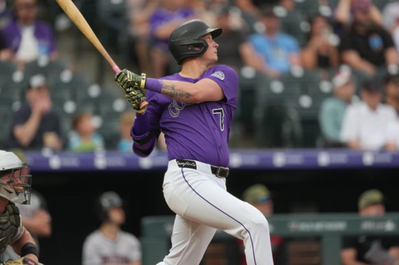 TJ Rumfield de los Rockies de Colorado le da seguimiento a su sencillo remolcador frente al abridor venezolano de los Diamondbacks de Arizona Eduardo Rodríguez el sábado 16 de mayo del 2026. (AP Foto/David Zalubowski)