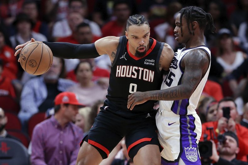 Dillon Brooks, de los Rockets de Houston, trata de avanzar con el balón frente a Davion Mitchell, de los Kings de Sacramento, en el partido del sábado 4 de noviembre de 2023 (AP Foto/Michael Wyke)