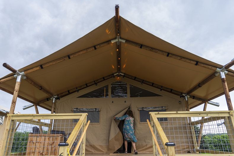 Beverly Cookie Grant entra a su tienda de campaña de lujo en el Centro para las Artes Bethel Woods, sede de la Feria de Arte y Música de Woodstock, el viernes 14 de junio de 2024, en Bethel, Nueva York. (Foto AP/Julia Nikhinson)