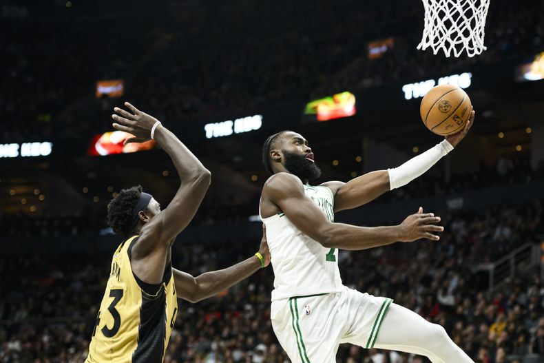 Jaylen Brown, base de los Celtics de Boston, salta para encestar frente a Pascal Siakam, de Toronto, en el duelo del viernes 17 de noviembre de 2023 (Christopher Katsarov/The Canadian Press via AP)