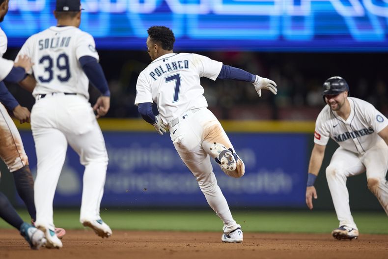 El dominicano Jorge Polanco es perseguido por sus compañeros de los Marineros de Seattle, tras conectar el sencillo que significó el triunfo sobre los Guardianes de Cleveland, el sábado 14 de junio de 2025 (AP Foto/John Froschauer)
