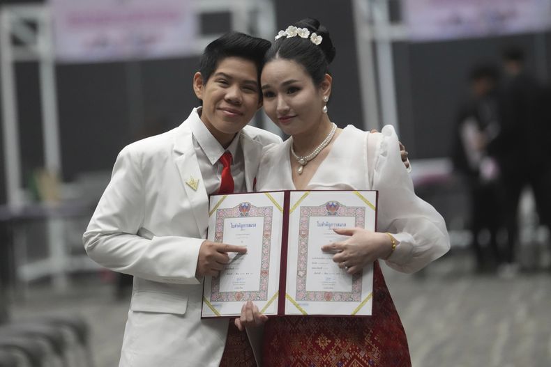 Kwanporn Kongpetch (izquierda) y Ploynaplus Chirasukon, que forman parte de la comunidad LGBTQ+, muestran su certificado de matrimonio tras la entrada en vigor de la ley que permite los enlaces entre personas del mismo sexo, en Bangkok, Tailandia, el 23 de junio de 2025. (AP Foto/Sakchai Lalit)