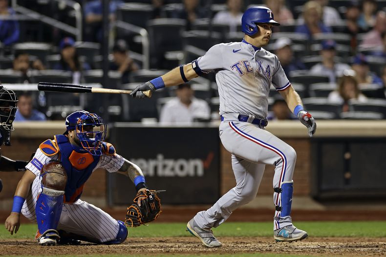 Nathaniel Lowe de los Rangers de Texas pega un sencillo de dos carreras en la novena entrada del juego ante los Mets de Nueva York el lunes 28 de agosto del 2023. (AP Foto/Adam Hunger)
