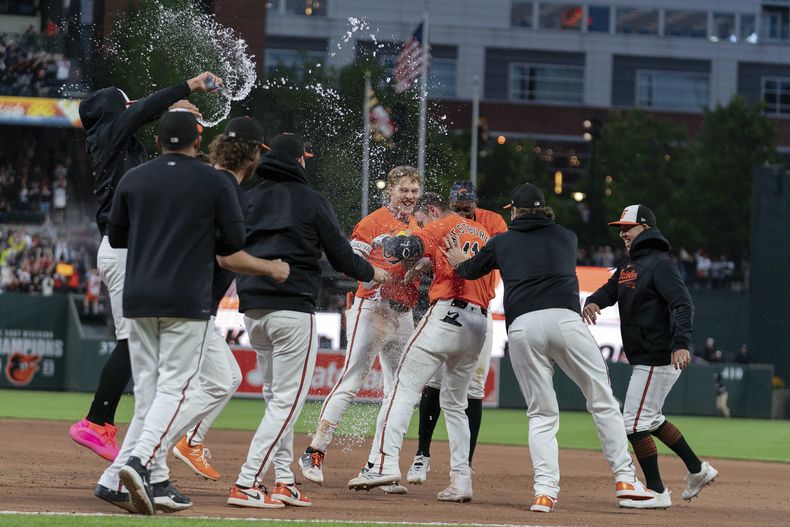 Jordan Westburg, de los Orioles de Baltimore, festeja con sus compañeros luego de pegar el sencillo de la victoria ante los Diamondbacks de Arizona, el sábado 11 de mayo de 2024 (AP Foto/José Luis Magaña)
