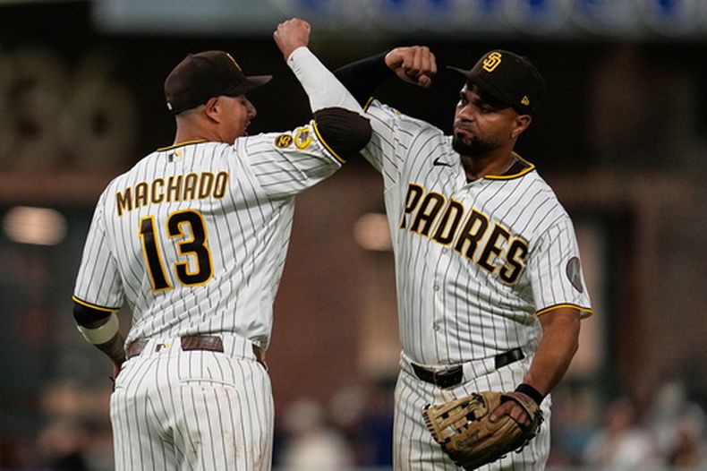 Manny Machado (13), de los Padres de San Diego, celebra con Xander Bogaerts después de la victoria de los Padres frente a los Bravos de Atlanta por 1-0, en el juego de béisbol de Grandes Ligas, el lunes 22 de junio de 2026, en San Diego. (AP Foto/Gregory Bull)
