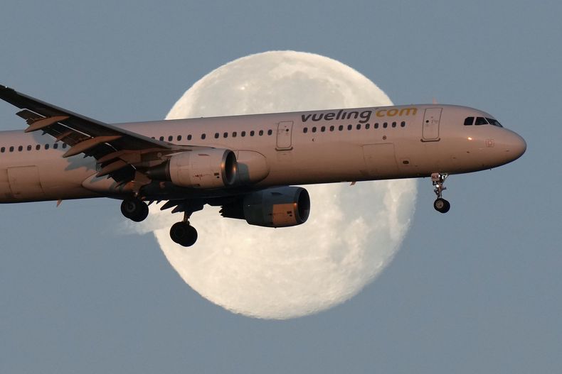 ARCHIVO – Un Airbus A321 de Vueling a punto de aterrizar en Lisboa al amanecer, con la luna de fondo, el 7 de febrero de 2023. (AP Foto/Armando Franca, Archivo)