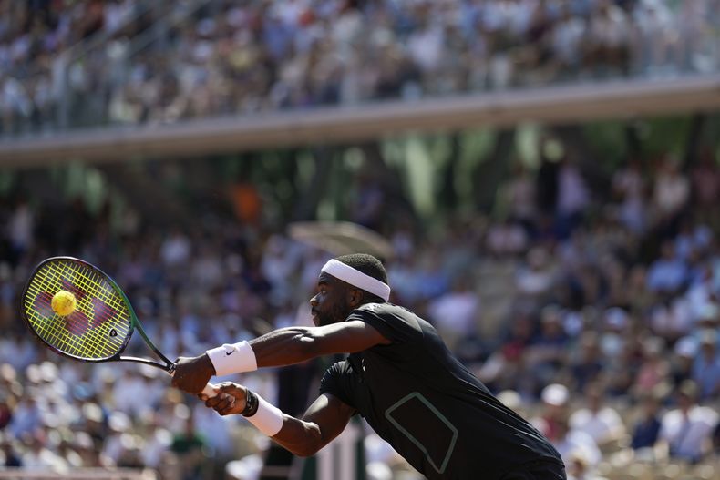 El estadounidense Frances Tiafoe le devuelve una volea al ruso Aslan Karatsev durante su partido de segunda ronda en el Abierto de Francia, el jueves 1 de junio de 2023, en el estadio Roland Garros de París. (AP Foto/Thibault Camus)