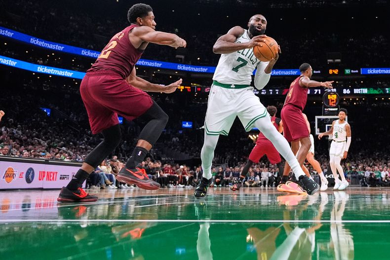 Jaylen Brown (7), de los Celtics de Boston, lleva el balón hacia la canasta, mientras DeAndre Hunter (12), de los Cavaliers de Cleveland, defiende durante la segunda mitad del juego de baloncesto de la NBA, el miércoles 29 de octubre de 2025, en Boston. (AP Foto/Charles Krupa)