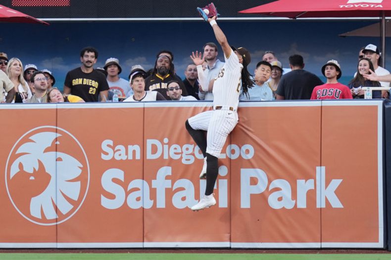 El dominicano Fernando Tatis Jr., de los Padres de San Diego, atrapa un elevado de su compatriota Rafael Devers, de los Gigantes de San Francisco, en el juego del jueves 30 de julio de 2026 (AP Foto/Gregory Bull)