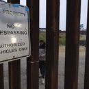 Migrantes esperan entre las vallas fronterizas que separan a Tijuana, México, de San Diego, EEUU, para solicitar asilo a las autoridades estadounidenses, el viernes 12 de abril de 2024, vistos desde San Diego. (AP Foto/Gregory Bull)