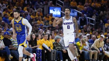 Malik Monk, base de los Kings de Sacramento, festeja luego de atinar un triple junto a Stephen Curry, base de los Warriors de Golden State, en el encuentro de playoffs disputado el viernes 28 de abril de 2023 (AP Foto/Godofredo A. Vásquez)