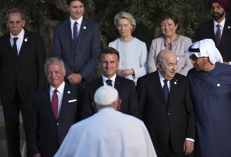 El presidente francés Emmanuel Macron sonríe mientras el papa Francisco camina para unirse a él y a otros mandatarios de los países miembros del G7 para una fotografía grupal en Borgo Egnazia, en el sur de Italia, el viernes 14 de junio de 2024. (Christopher Furlong/Pool Photo vía AP)
