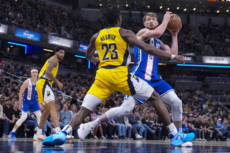 Domantas Sabonis, alero lituano de los Kings de Sacramento, busca driblar a Aaron Nesmith, de los Pacers de Indiana, el viernes 2 de febrero de 2024 (AP Foto/Michael Conroy)