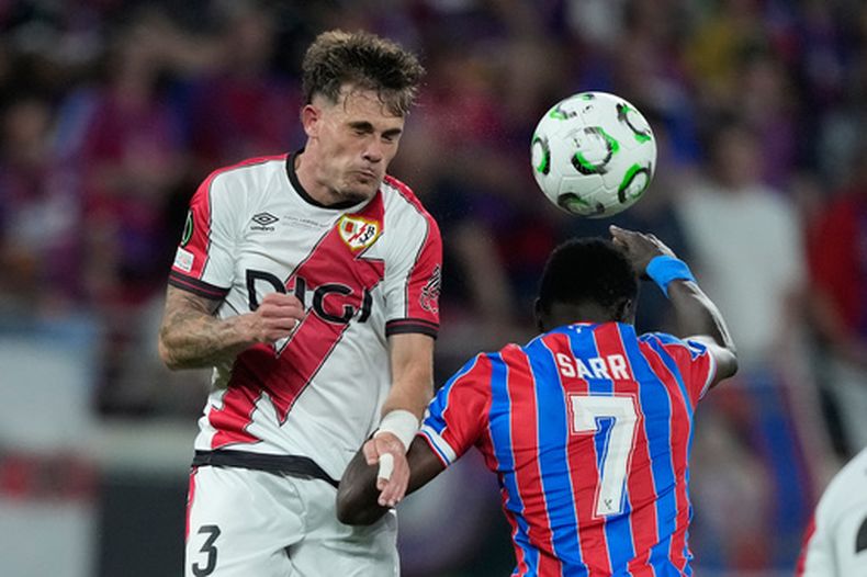ARCHIVO - Pep Chavarría, del Rayo [Vallecano], e Ismaila Sarr, del Crystal Palace, saltan por el balón durante la final de la Liga Conferencia de la UEFA entre el Crystal Palace y el Rayo Vallecano en Leipzig, Alemania, el 27 de mayo de 2026. (Foto AP/Ebrahim Noroozi, Archivo)