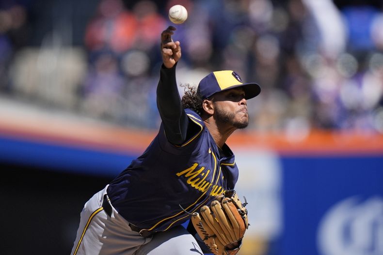 El abridor dominicano de los Cerveceros de Milwaukee Freddy Peralta lanza en la primera entrada del juego del Día Inaugural pospuesto por lluvia ante los Mets de Nueva York el viernes 29 de marzo del 2024. (AP Foto/Frank Franklin II)