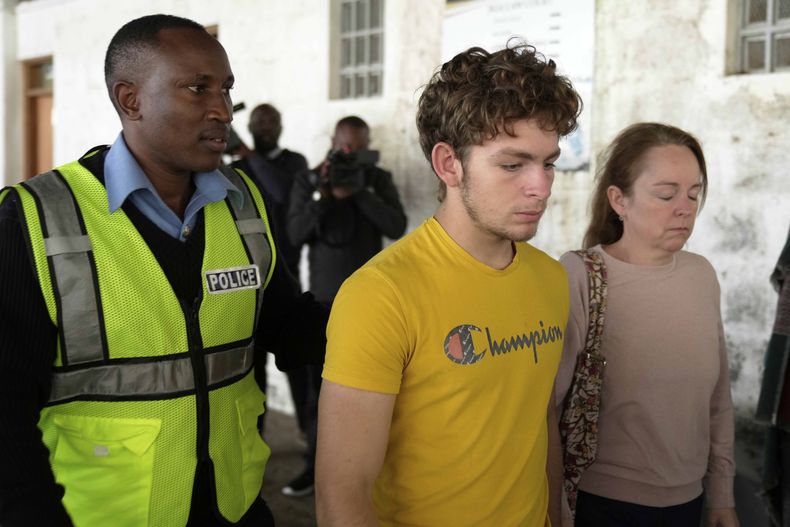 El ciudadano belga Lornoy David, centro, que admitió los cargos relacionados con la posesión ilegal y el tráfico de hormigas reina vivas para venderlas como mascotas exóticas, camina fuera de la Corte Penal del Aeropuerto Internacional Jomo Kenyatta en Nairobi, Kenia el miércoles 23 de abril de 2025. (AP Foto/Brian Inganga)