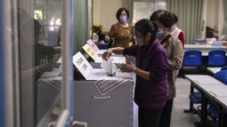 Varias personas depositan su voto en una casilla electoral durante las elecciones el sábado 13 de enero de 2024, en Nueva Taipéi, Taiwán. (AP Foto/Louise Delmotte)
